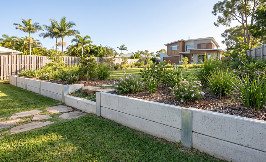 Low concrete sleeper garden retaining wall under one metre high in a Gold Coast residential backyard.